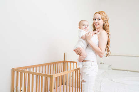 Mother playing with baby on the bed