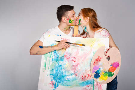 The guy and the girl draw paints on the easelの写真素材