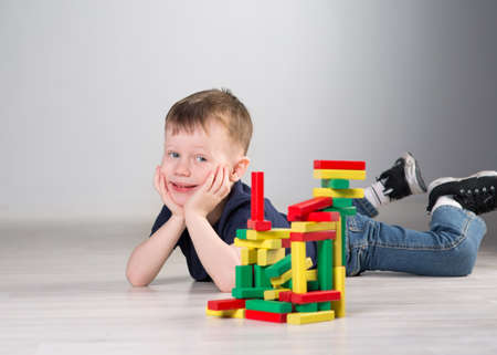 Boy playing with wooden cubes on the floor