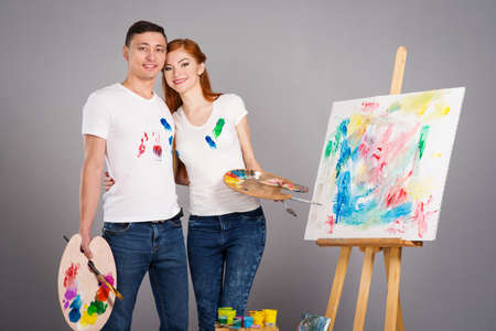 The guy and the girl draw paints on the easelの写真素材