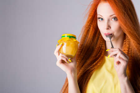 Girl holding a jar of honey in her handsの写真素材