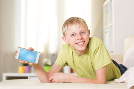 Teenager is playing in the phone in the room