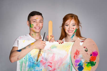 The guy and the girl draw paints on the easelの写真素材