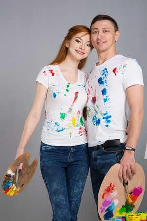 The guy and the girl draw paints on the easel