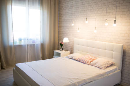 White bed in the interior of the bedroomの写真素材