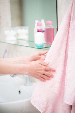 The boy is washing his hands in the bathroomの写真素材