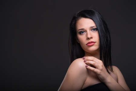 Woman in black dress on a dark backgroundの写真素材