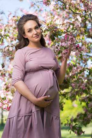 Young beautiful pregnant woman in the parkの写真素材