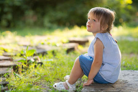 The girl is sitting on the grassの写真素材