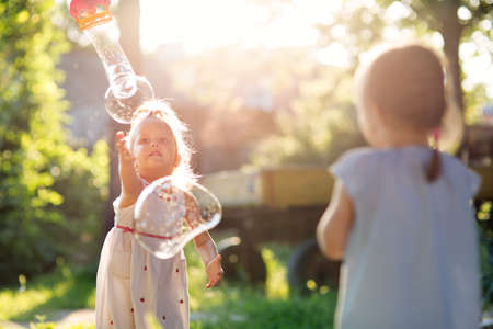 Children play with soap bubbles outdoorsの写真素材