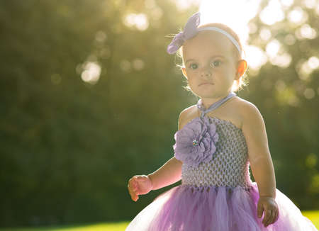 A little girl of fourteen months old on the grassの写真素材