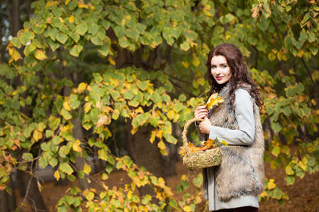 young woman is walking in the autumn parkの写真素材