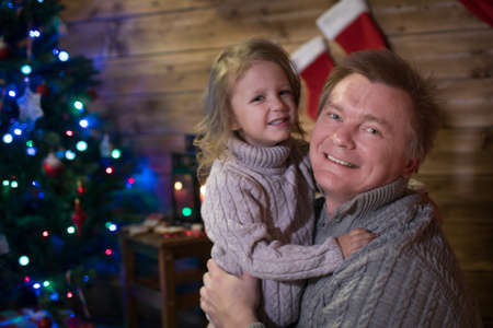Dad and daughter at the Christmas tree, happy Christmas! Family meet at home christmasの写真素材