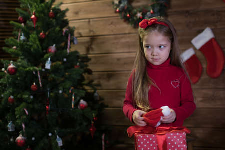 baby girl meet a happy christmas, five year old baby in a room with Christmas tree and giftsの写真素材