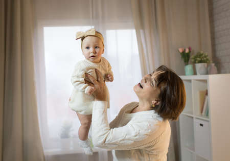 grandmother and granddaughter in the room, happy family with the baby