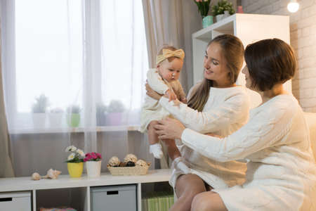 grandmother mum and granddaughter in the room, happy family with the baby