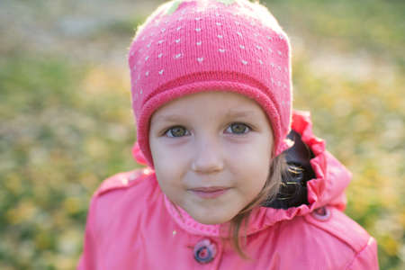 girl collect autumn leaves, baby three years old on a walkの写真素材