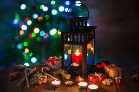 lantern with a candle against the background of Christmas fir-tree lightsの写真素材