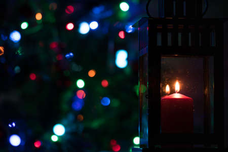 lantern with a candle against the background of Christmas fir-tree lights