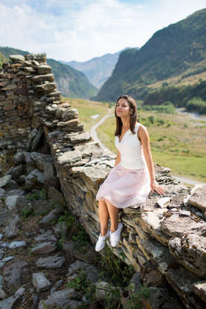 Young woman near a stone wall, an abandoned house の写真素材
