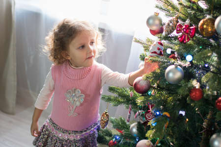 Girl playing in the room with a Christmas treeの写真素材