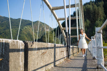 Young woman in a white dress on an old bridge in Georgiaの写真素材