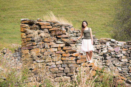 Young woman near a stone wall, an abandoned house の写真素材