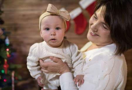 Baby girl in grandmother's arms on a happy Christmas dayの写真素材