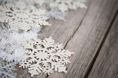 white tinsel and snowflakes on an old wooden boardの写真素材