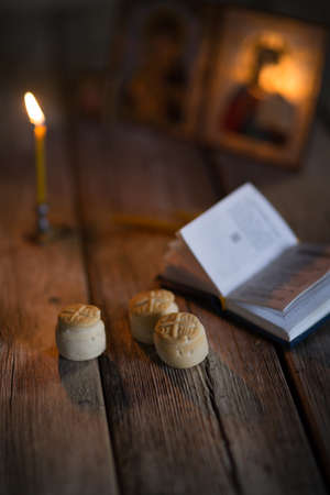 A burning candle against the background of orthodox icons in a dark roomの写真素材