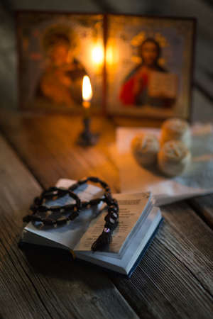 A burning candle against the background of orthodox icons in a dark roomの写真素材