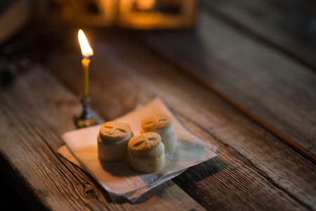 A burning candle against the background of orthodox icons in a dark roomの写真素材