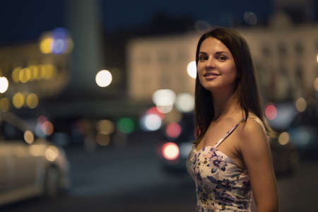 Beautiful young woman is walking in the night city.の写真素材