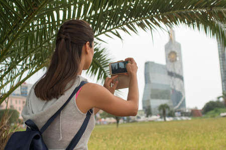 Beautiful young woman taking pictures of beautiful views of the city of Batumi, Georgia,