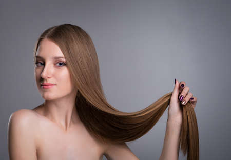 young woman with long beautiful hair, Young long-haired woman with well-groomed hair の写真素材