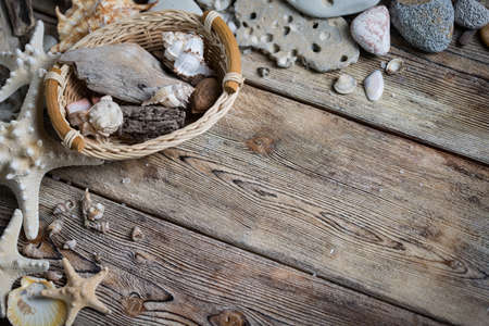 Beautiful composition of seashells and stones on a marine theme on old boardsの写真素材