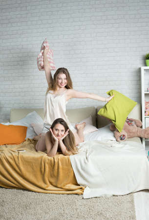 Two young girls indulge in the bedroom, a pajama partyの写真素材