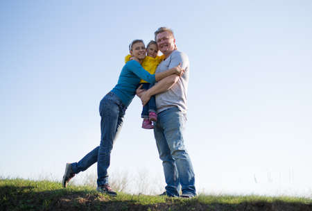 Family with a child of three years standing in the sun on the grass