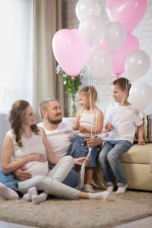 Family with two children and a pregnant motherの写真素材