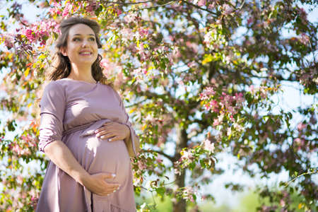Pregnant young woman in a spring park