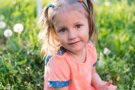 Little girl is playing on the grass, four years old