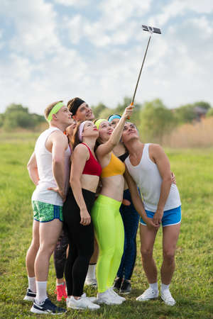 Group of sports people on the grass are photographed on the phoneの写真素材