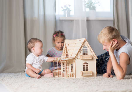 Children play in a room with a doll houseの写真素材