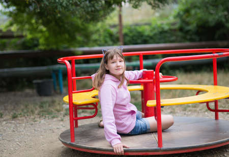 A teenage girl is engaged in children's exercise equipment, a girl of thirteen years swings on a swingの写真素材