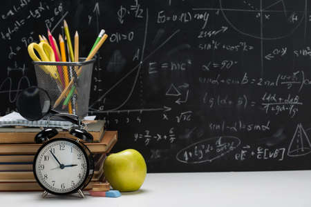 School background, with a stack of books on the background of a school board
