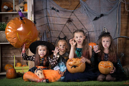 Children in Halloween costumes with pumpkins and sweets