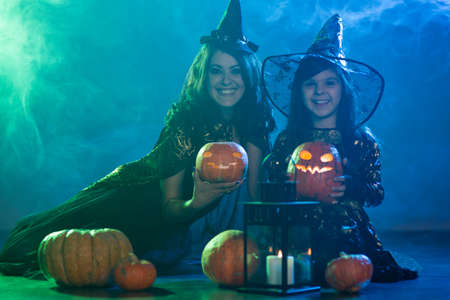 Mom and daughter in costumes for a holiday of halloweenの写真素材
