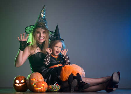 Mom and daughter in costumes for a holiday of halloweenの写真素材