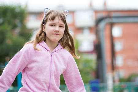 A teenage girl walks in the town yardの写真素材