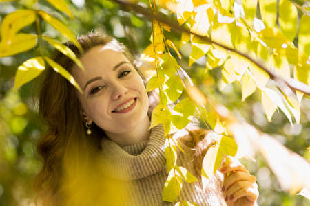Young beautiful woman in autumn park